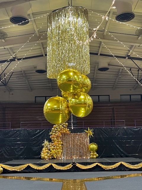 Gold metallic balloon display with chandelier installation
