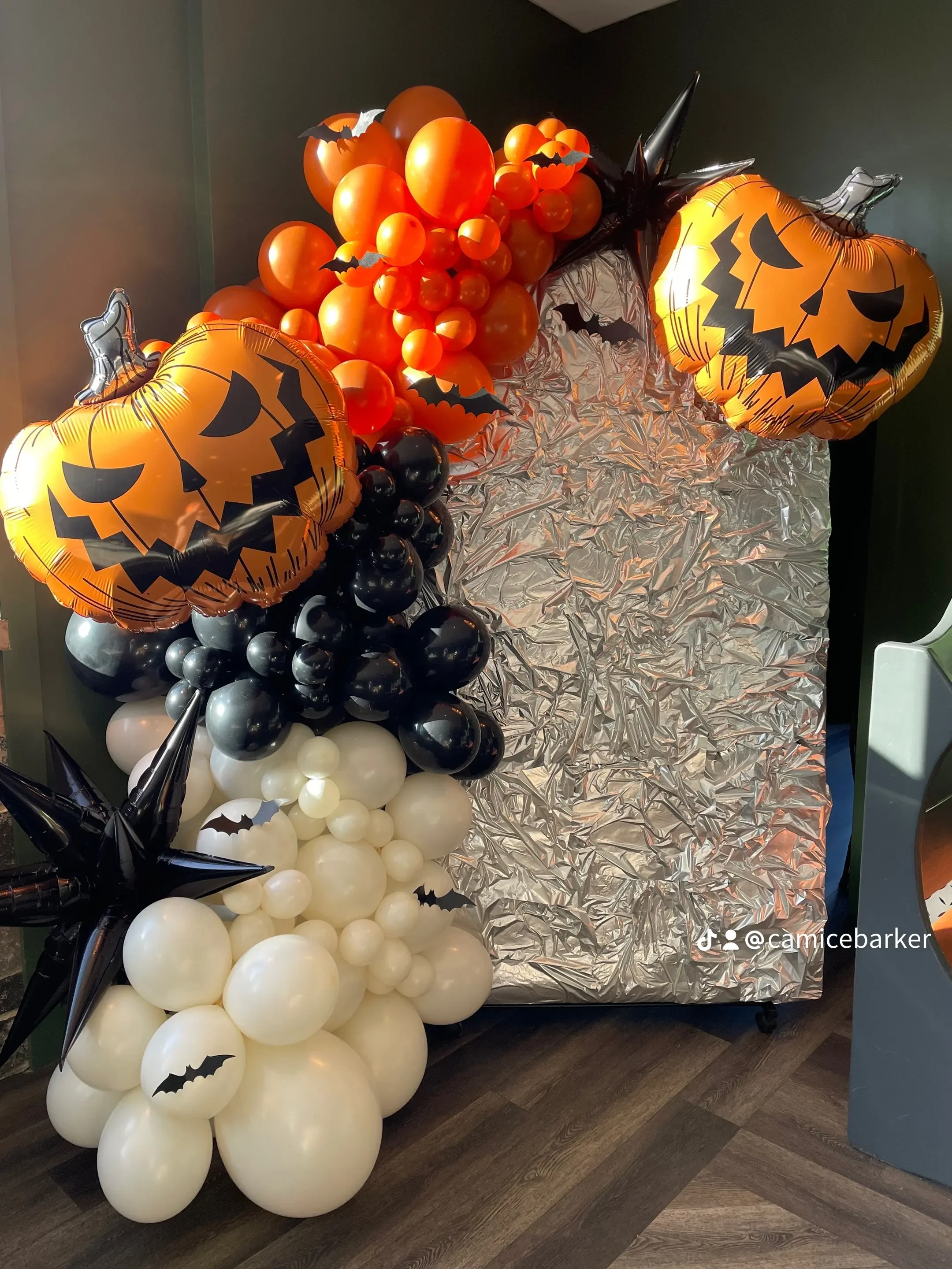Halloween jack-o'-lantern balloon garland with silver backdrop